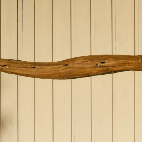 Glatte aber zum Teil rissige Holzoberfläche der Unikat-Garderobe Fließholz mit sechs Haken. Nachhaltig & handgemacht.
