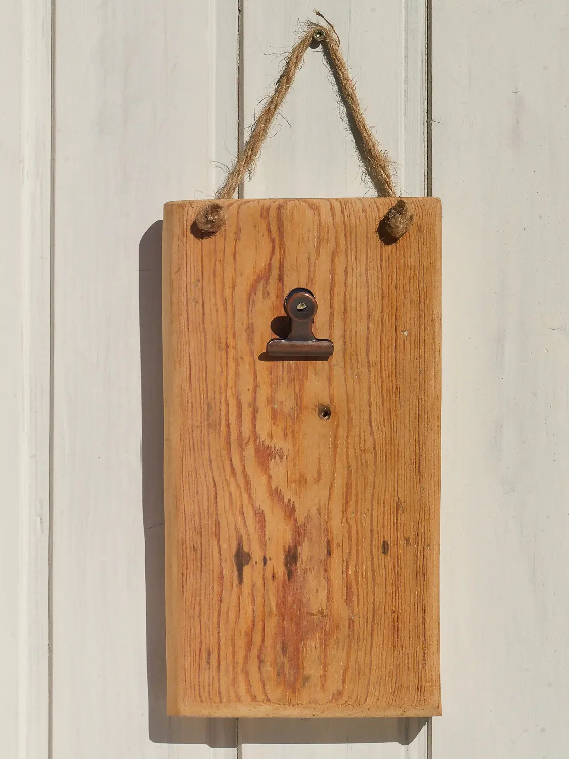 Aufnahme eines handgearbeiteten Wand-Notizhalters aus recyceltem Altholz im skandinavischen Stil. Holzmaserung ist sichbat und Befestigungsclip für Notizen ist vorhanden. Nachhaltig & handgefertig.
