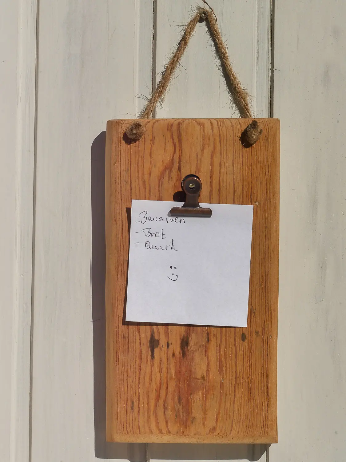 Aufnahme eines handgearbeiteten Wand-Notizhalters aus recyceltem Altholz im skandinavischen Stil. Holzmaserung ist sichbat und Befestigungsclip für Notizen ist vorhanden. Nachhaltig & handgefertig.